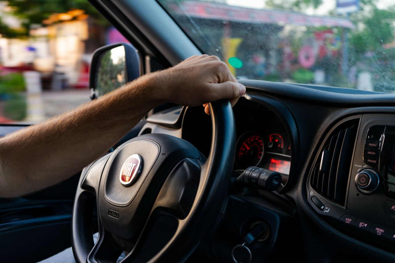 our-experience Close-up of a hand on a Fiat steering wheel while driving in Fethiye, Türkiye.